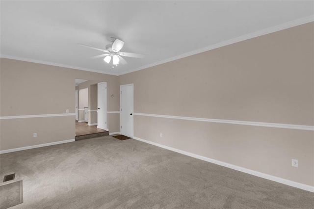 empty room with a ceiling fan, crown molding, baseboards, and carpet floors