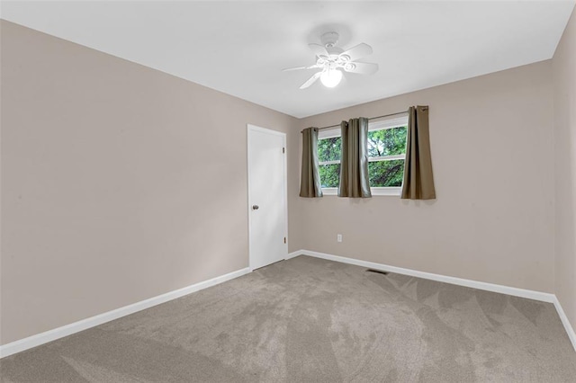 spare room featuring carpet floors, baseboards, and ceiling fan