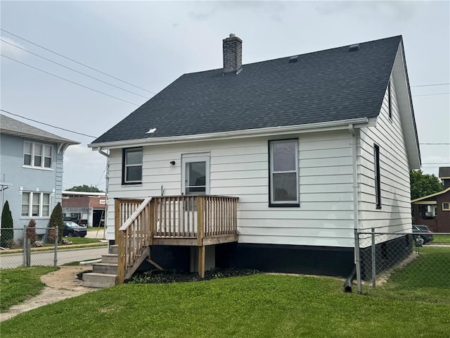 rear view of property with a chimney, a deck, and roof with shingles