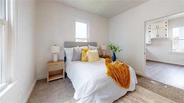 bedroom featuring baseboards and light carpet