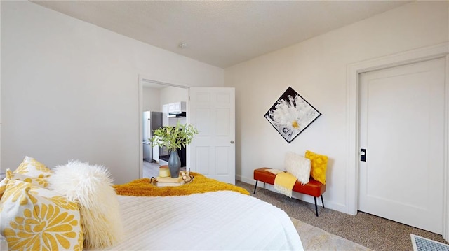 bedroom featuring carpet, freestanding refrigerator, and baseboards