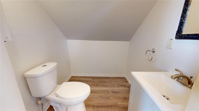 bathroom featuring vaulted ceiling, wood finished floors, toilet, and vanity