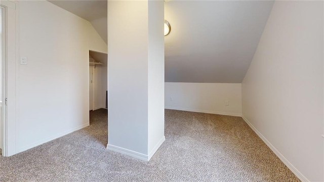 additional living space featuring carpet, vaulted ceiling, and baseboards