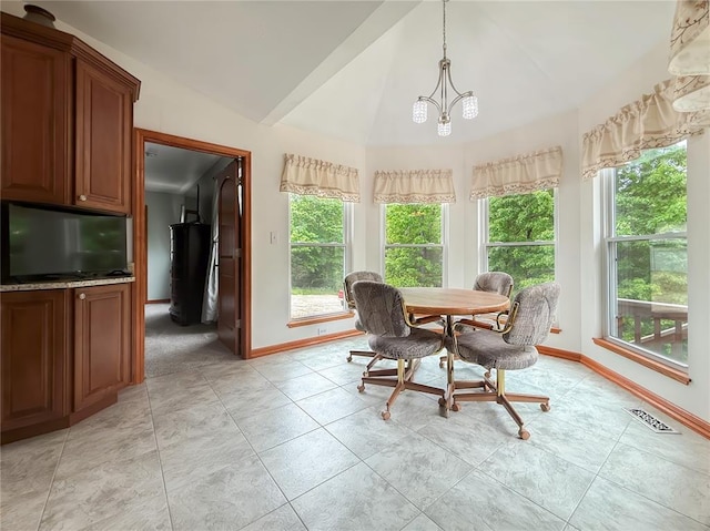 dining area featuring baseboards, vaulted ceiling, plenty of natural light, and light tile patterned floors