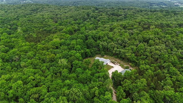 aerial view of property and surrounding area featuring a heavily wooded area