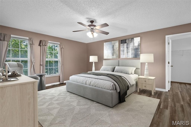 881 Sara Beth Ct, Saint Peters, MO 63376 - bedroom with wood finished floors, a textured ceiling, a spacious closet, a ceiling fan, and a closet