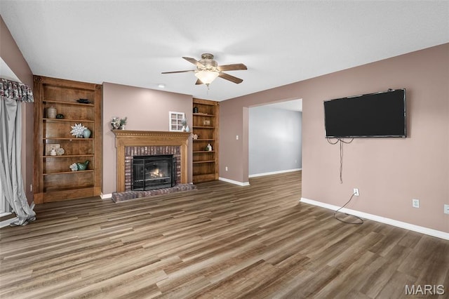 881 Sara Beth Ct, Saint Peters, MO 63376 - unfurnished living room with ceiling fan, a brick fireplace, wood finished floors, and built in shelves