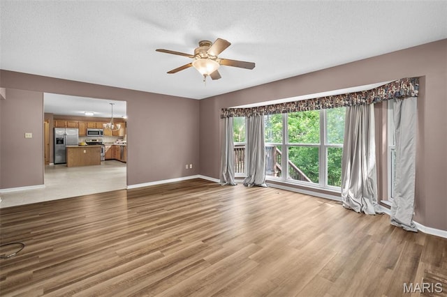 881 Sara Beth Ct, Saint Peters, MO 63376 - unfurnished living room featuring ceiling fan, light wood-style floors, and a textured ceiling