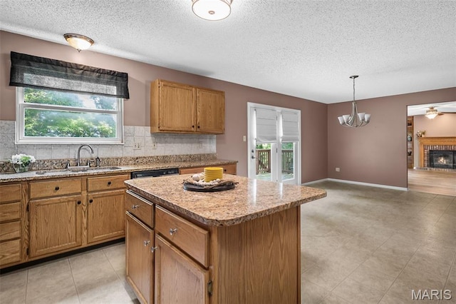 881 Sara Beth Ct, Saint Peters, MO 63376 - kitchen with a textured ceiling, a center island, decorative backsplash, hanging light fixtures, and a fireplace