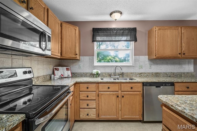 881 Sara Beth Ct, Saint Peters, MO 63376 - kitchen with stainless steel appliances, tasteful backsplash, brown cabinetry, light stone countertops, and a textured ceiling
