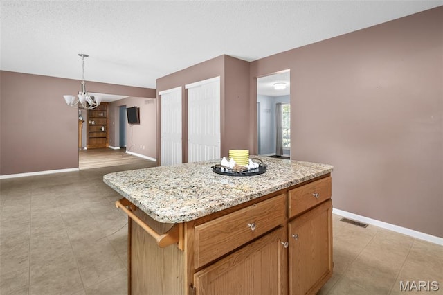 881 Sara Beth Ct, Saint Peters, MO 63376 - kitchen featuring a chandelier, decorative light fixtures, light stone countertops, and a kitchen island
