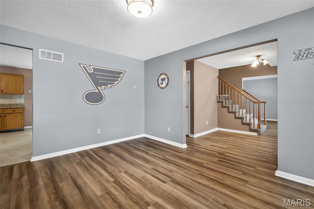 881 Sara Beth Ct, Saint Peters, MO 63376 - spare room with stairway, a textured ceiling, and wood finished floors