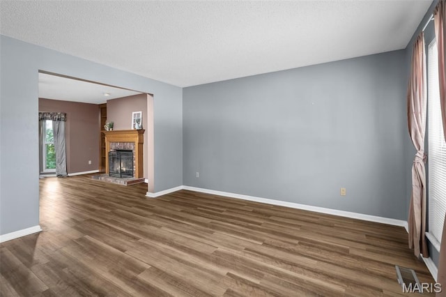 881 Sara Beth Ct, Saint Peters, MO 63376 - unfurnished living room featuring wood finished floors, a fireplace with raised hearth, and a textured ceiling