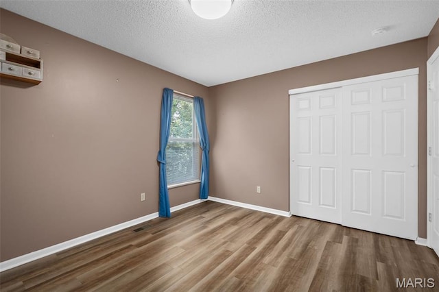 881 Sara Beth Ct, Saint Peters, MO 63376 - unfurnished bedroom featuring wood finished floors, a closet, and a textured ceiling