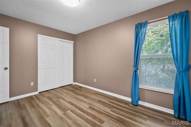 881 Sara Beth Ct, Saint Peters, MO 63376 - unfurnished bedroom with wood finished floors, a closet, and a textured ceiling