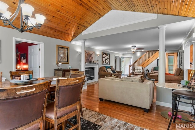 15092 State Highway Ad, Dexter, MO 63841 - dining area featuring ornate columns, vaulted ceiling, a glass covered fireplace, a chandelier, and wood finished floors