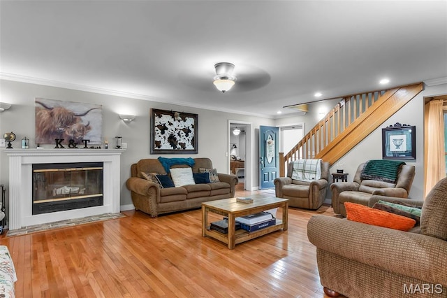 15092 State Highway Ad, Dexter, MO 63841 - living area featuring ornamental molding, light wood-style flooring, stairs, a glass covered fireplace, and recessed lighting