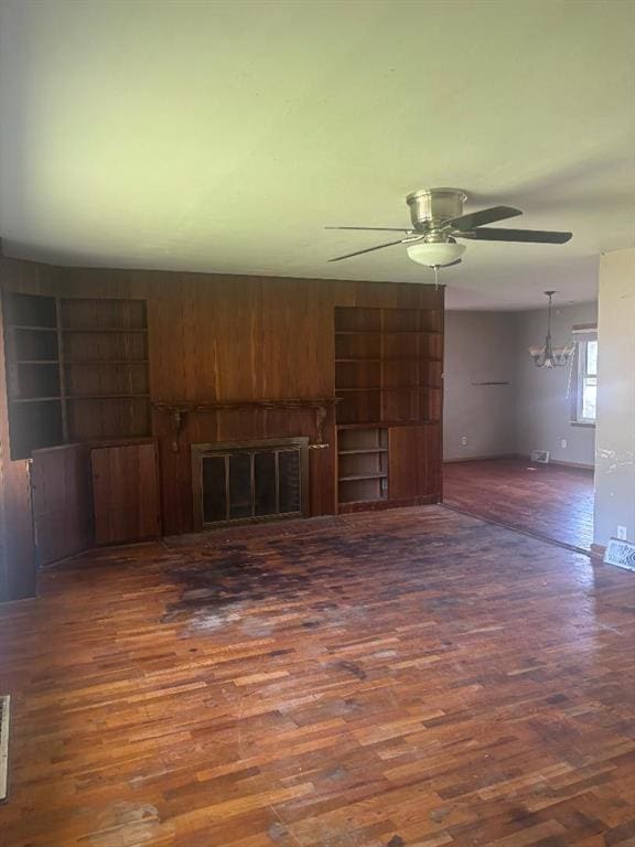 902 S Hackman St, Staunton, IL 62088 - unfurnished living room featuring wood finished floors, ceiling fan, a fireplace, and baseboards