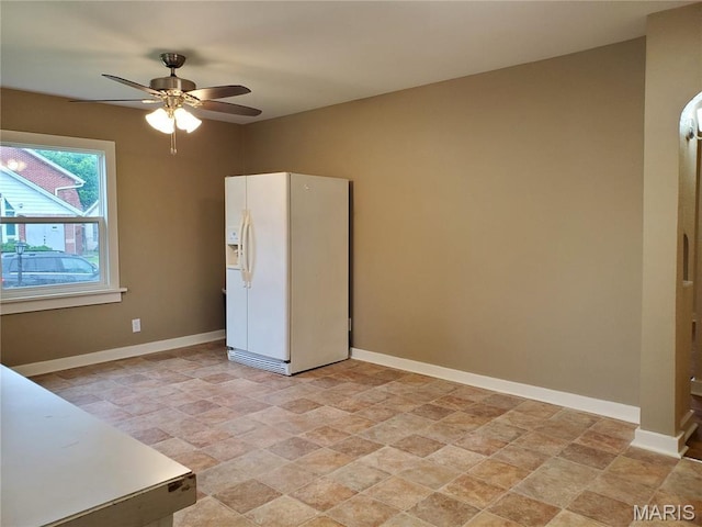 1225 Bloomfield Rd, Cape Girardeau, MO 63703 - unfurnished bedroom featuring white fridge with ice dispenser, stone finish flooring, baseboards, and ceiling fan