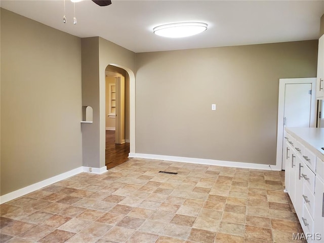 1225 Bloomfield Rd, Cape Girardeau, MO 63703 - unfurnished room featuring arched walkways, stone finish floors, ceiling fan, and baseboards