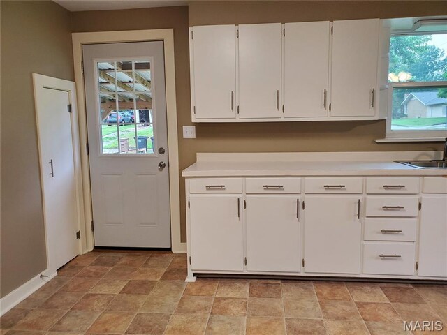 1225 Bloomfield Rd, Cape Girardeau, MO 63703 - kitchen with stone finish flooring, light countertops, white cabinetry, and a sink