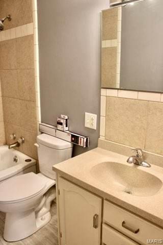 1225 Bloomfield Rd, Cape Girardeau, MO 63703 - bathroom featuring vanity, toilet, shower / bath combination, and tile walls