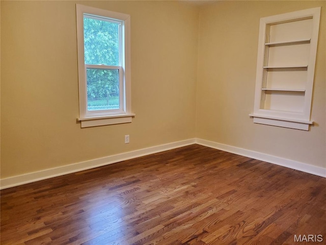 1225 Bloomfield Rd, Cape Girardeau, MO 63703 - empty room featuring dark wood-style flooring, baseboards, and built in features