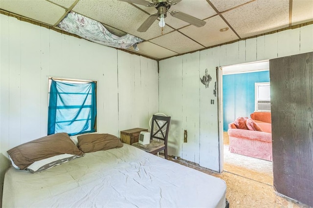 bedroom with a paneled ceiling, carpet floors, and ceiling fan