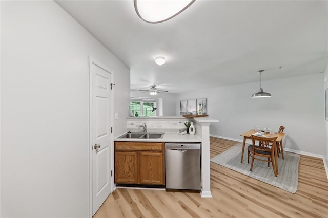 1625 Forest Springs Ln Unit A, Ballwin, MO 63021 - kitchen with stainless steel dishwasher, a sink, light wood-style flooring, brown cabinetry, and a peninsula