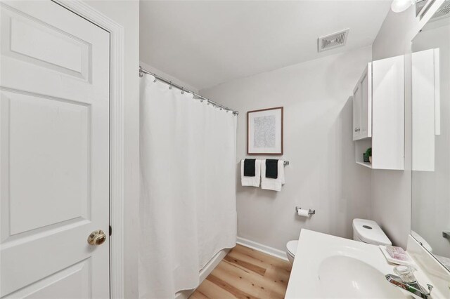 1625 Forest Springs Ln Unit A, Ballwin, MO 63021 - full bathroom with toilet, wood finished floors, vanity, baseboards, and curtained shower
