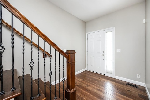 entryway with wood-type flooring, baseboards, and stairs