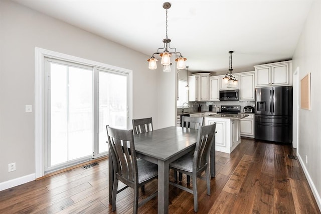 dining space with dark wood-type flooring and baseboards