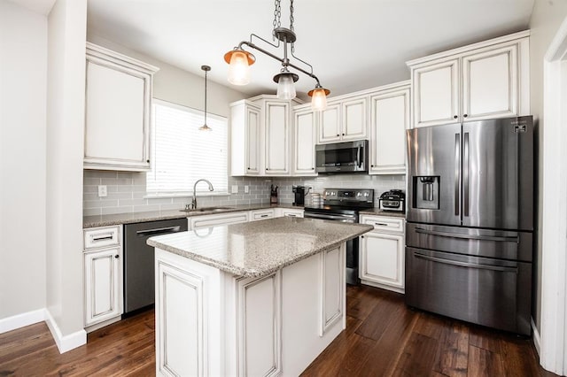 kitchen featuring stainless steel appliances, a sink, dark wood-style flooring, tasteful backsplash, and pendant lighting