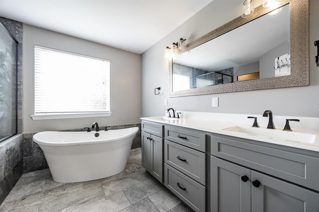 full bathroom with plenty of natural light, double vanity, tiled shower, and a freestanding tub