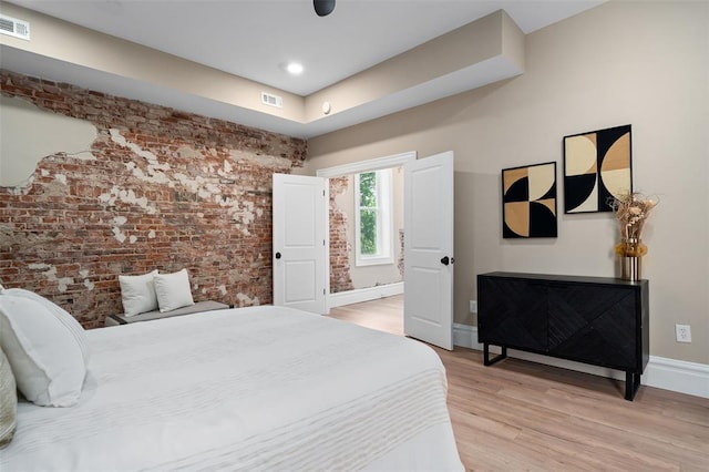 3235 S Jefferson Ave, Saint Louis, MO 63118 - bedroom with brick wall, light wood-style flooring, and baseboards