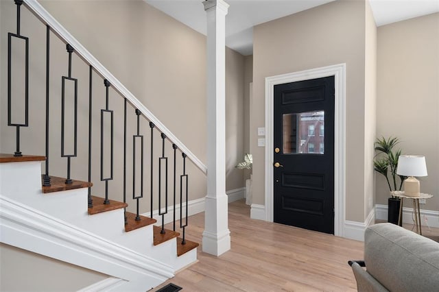 3235 S Jefferson Ave, Saint Louis, MO 63118 - entrance foyer with light wood-style flooring, stairway, baseboards, and ornate columns