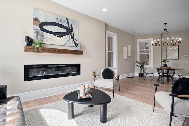 3235 S Jefferson Ave, Saint Louis, MO 63118 - living area featuring a glass covered fireplace, wood finished floors, a chandelier, baseboards, and recessed lighting
