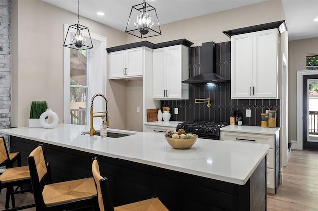 3235 S Jefferson Ave, Saint Louis, MO 63118 - kitchen with a sink, wall chimney exhaust hood, black gas stove, plenty of natural light, and recessed lighting