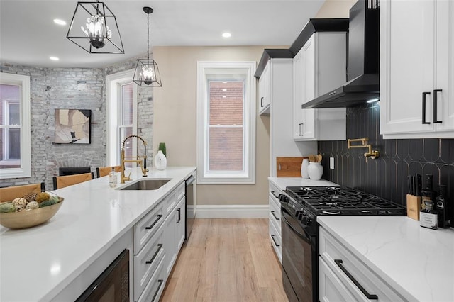 3235 S Jefferson Ave, Saint Louis, MO 63118 - kitchen featuring black range with gas stovetop, wall chimney exhaust hood, a sink, backsplash, and light wood-style floors