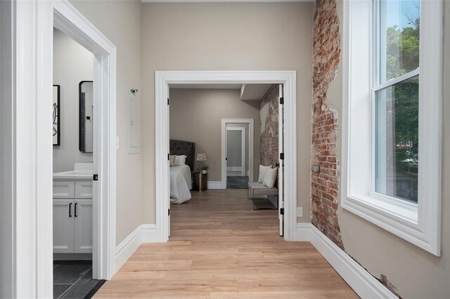 3235 S Jefferson Ave, Saint Louis, MO 63118 - corridor featuring brick wall, light wood finished floors, and baseboards