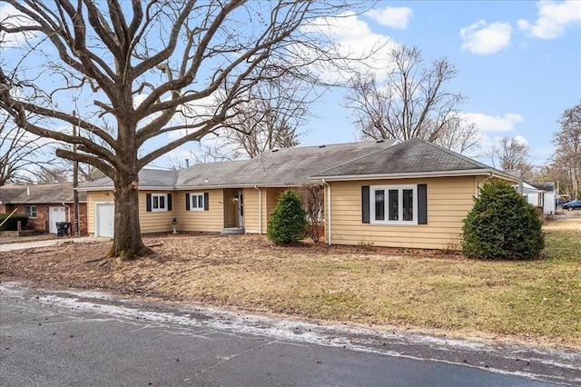 single story home featuring an attached garage and a front yard