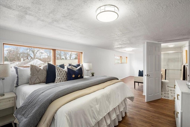 bedroom featuring dark wood-type flooring, a textured ceiling, and multiple windows