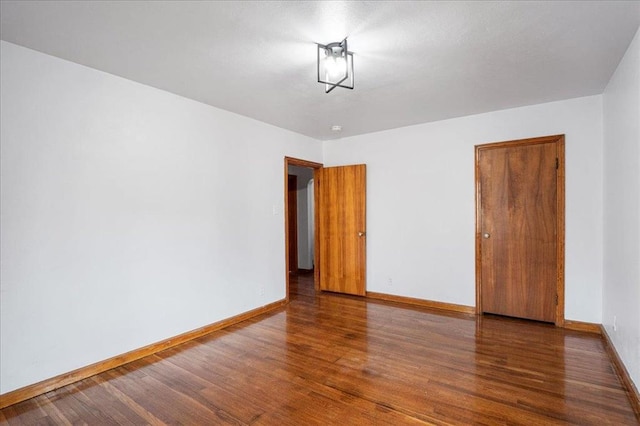 spare room with wood finished floors and baseboards