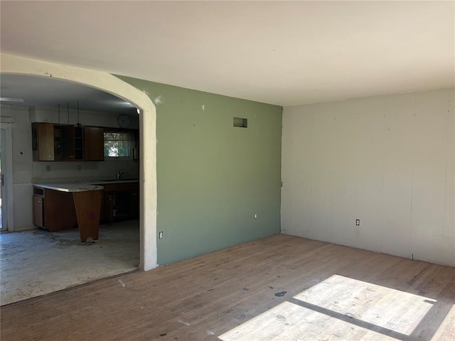 12219 Peter Moore Ln, De Soto, MO 63020 - unfurnished room with light wood finished floors, arched walkways, and a sink
