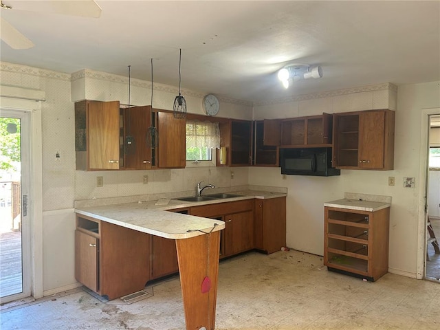 12219 Peter Moore Ln, De Soto, MO 63020 - kitchen featuring light flooring, black microwave, a peninsula, plenty of natural light, and wallpapered walls
