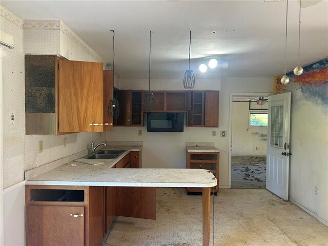12219 Peter Moore Ln, De Soto, MO 63020 - kitchen with a peninsula, brown cabinetry, light countertops, a sink, and light flooring