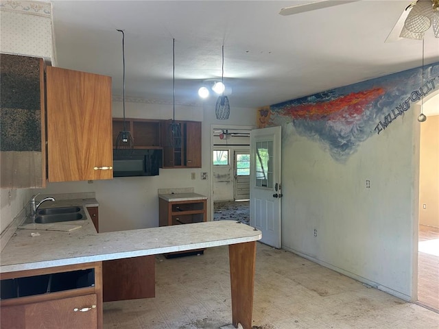 12219 Peter Moore Ln, De Soto, MO 63020 - kitchen featuring a sink, black microwave, light floors, brown cabinets, and a peninsula
