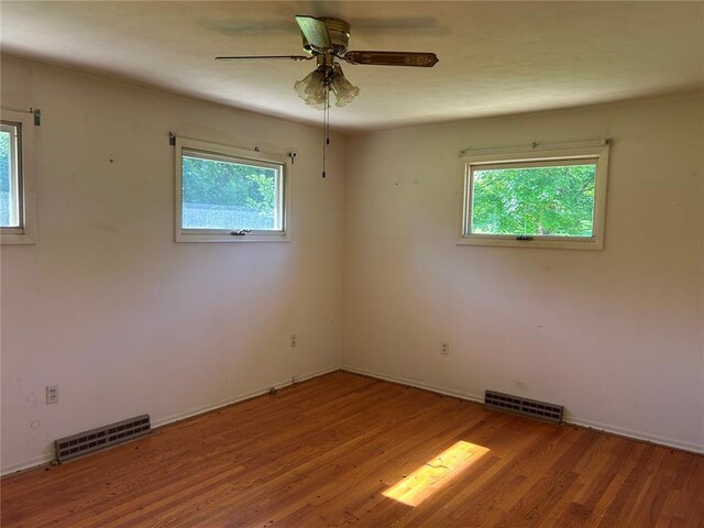12219 Peter Moore Ln, De Soto, MO 63020 - spare room with plenty of natural light, wood finished floors, ceiling fan, and baseboards
