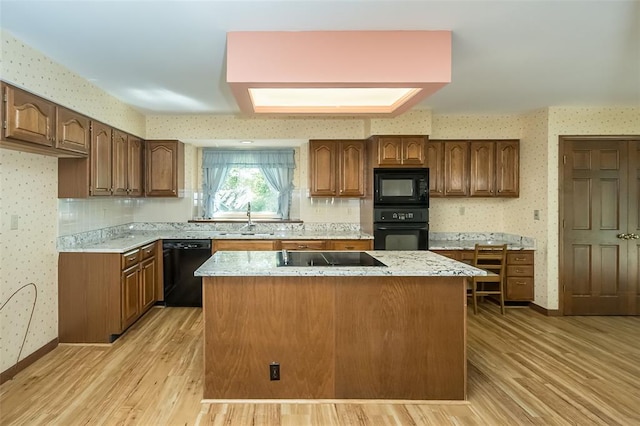 14 Wimbly Pl, Saint Charles, MO 63301 - kitchen with black appliances, wallpapered walls, a sink, a center island, and light wood-type flooring