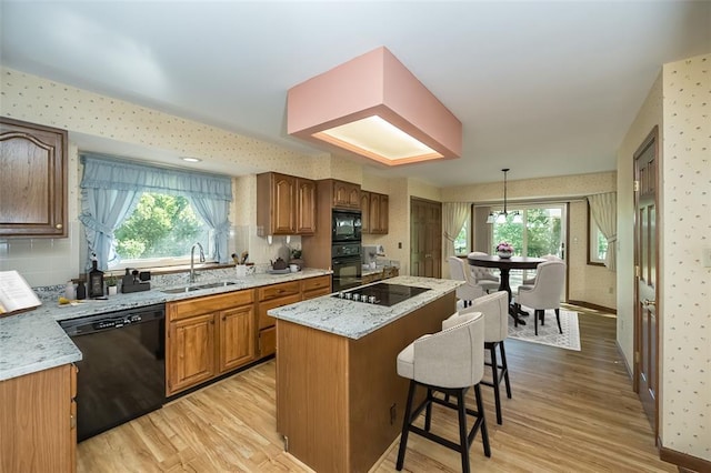 14 Wimbly Pl, Saint Charles, MO 63301 - kitchen with a sink, black appliances, light wood-style flooring, wallpapered walls, and healthy amount of natural light